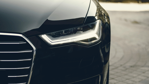 A close up shot of the headlight of a black car