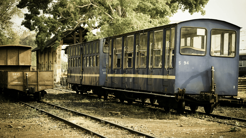 Vintage Nilgiri toy train carriage standing beside a railway platform