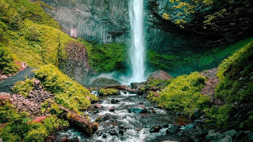 view of a waterfall amidst the greenery of a hill