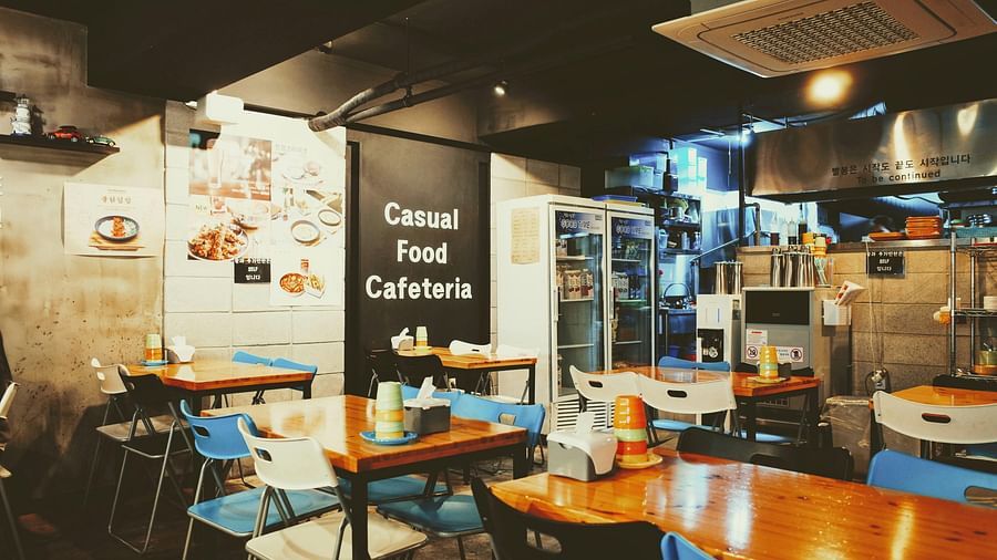 A casual and eclectic restaurant or cafe with diverse seating arrangements and warm lighting.