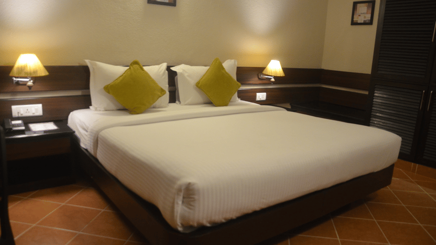 Standard Room at Green Pastures, Kodaikanal featuring a bed, two lamps on the bedside table of either side of the bed.