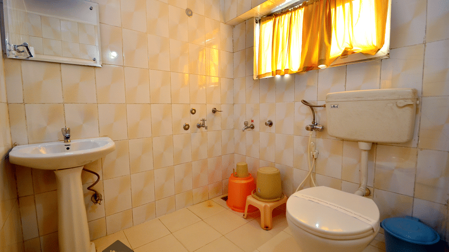 A washroom with sink and a toilet at BN Tourist Home, Ooty.