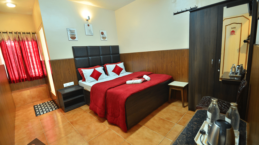 Image of a room with a bed, wardrobe, electric kettle and water bottle at BN Tourist Home, Ooty
