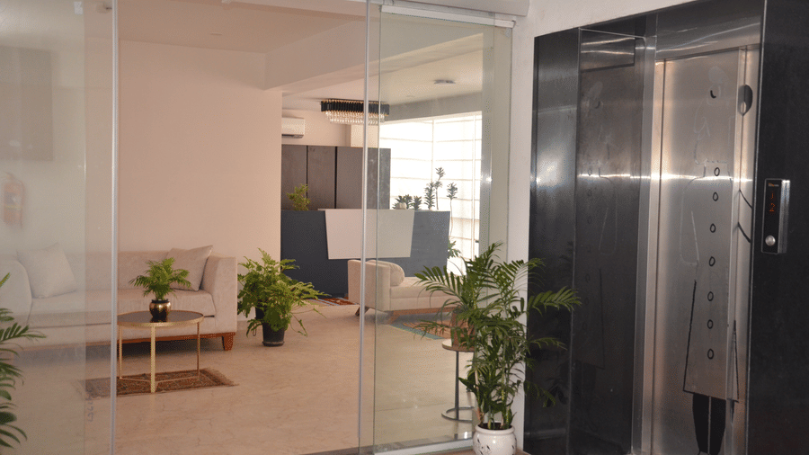 A beautiful lobby area separated with a transparent glass door featuring an elevator - Lords Eco Inn Belagavi