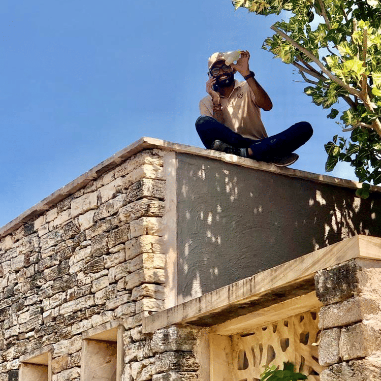 Man sitting on a terrace next to a tree