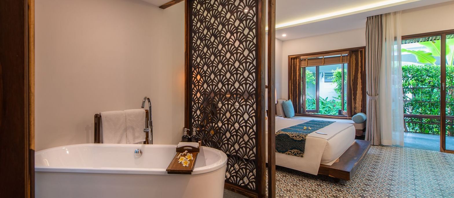 A bathtub in our living room separated by a wooden door from the bedroom - Alibu Resort Nha Trang