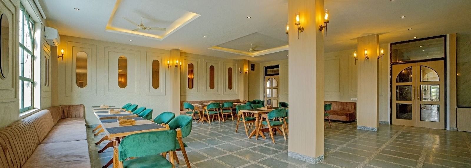 Dining area at Grassfield Riviera Resort, Jaipur, featuring stylish seating, soft lighting, and a spacious, elegant atmosphere.
