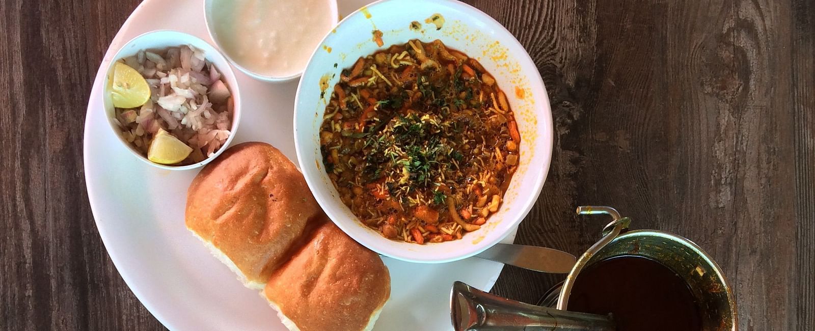 Aerial view of Maharashtrian dishes kept on plates on top of a table.