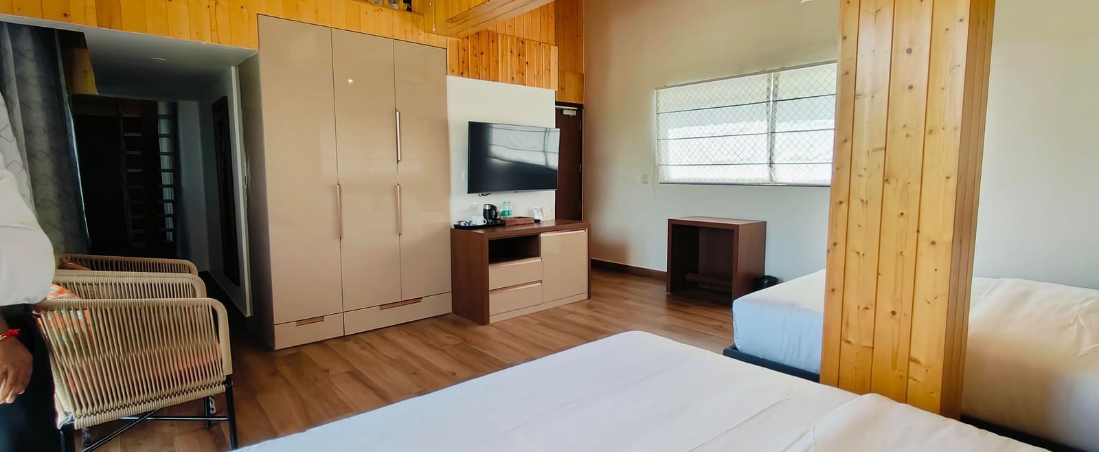 A family suite with wooden interiors at Eminence The Corbett with two beds in the room.