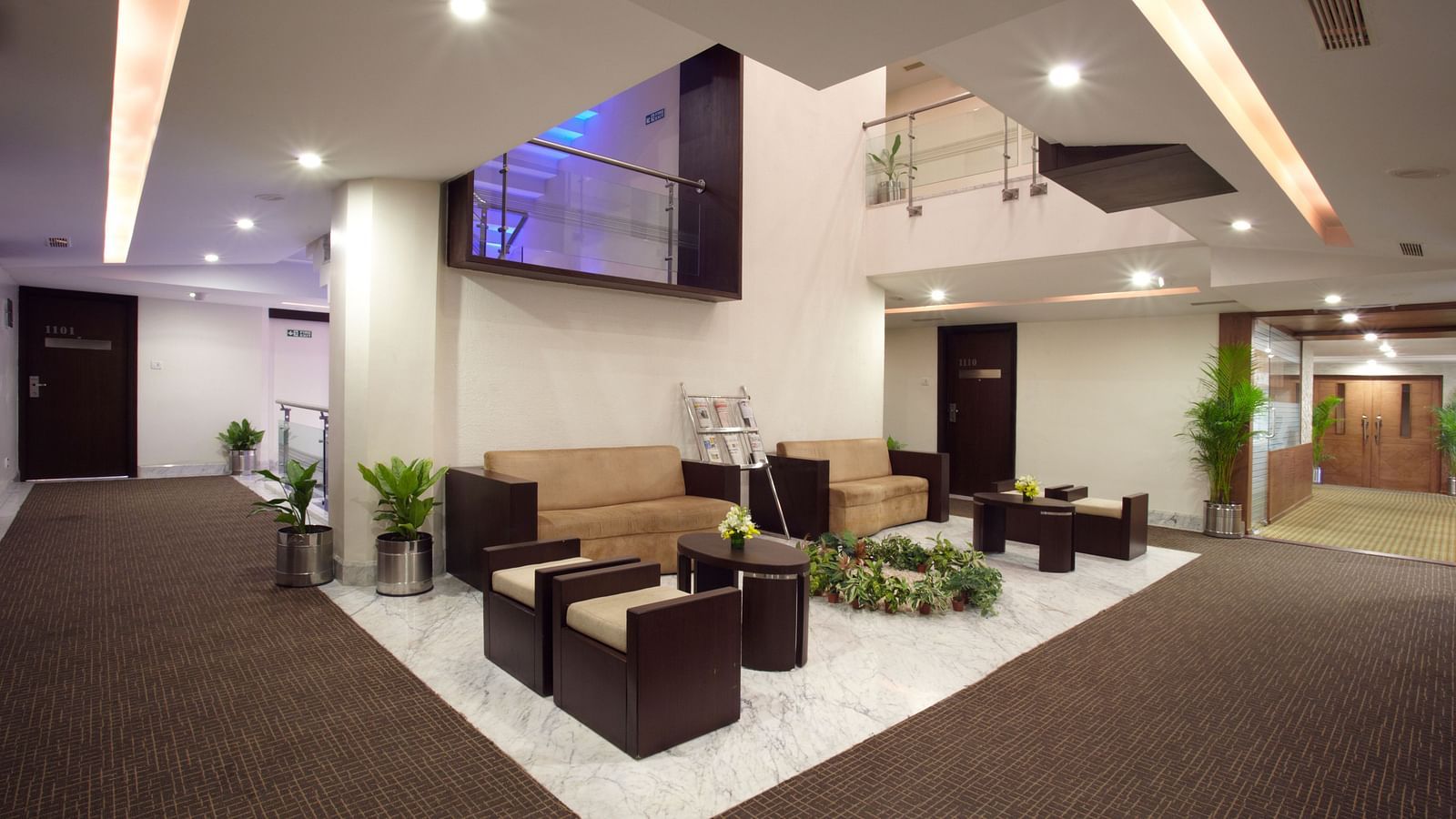 An expansive hotel lobby featuring plush seating, contemporary decor, a flat-screen TV, and a welcoming ambience for guests - The President Hotel Jayanagar, Bangalore