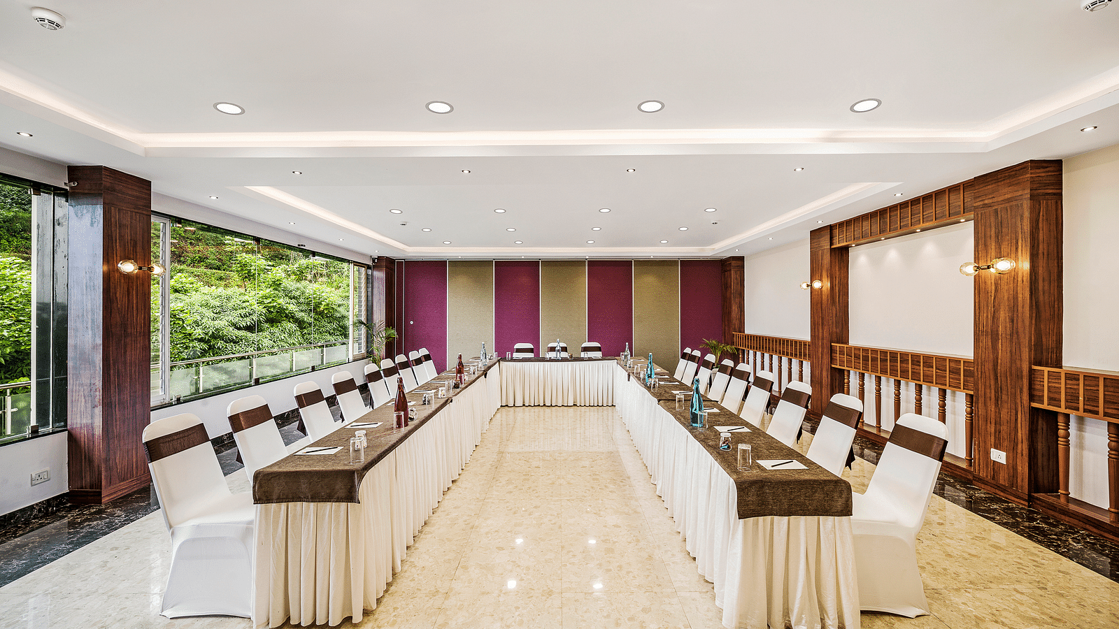 An image of a banquet space which is brightly lit with seating arrangement - GReaT Trails Kodaikanal By GRT Hotels