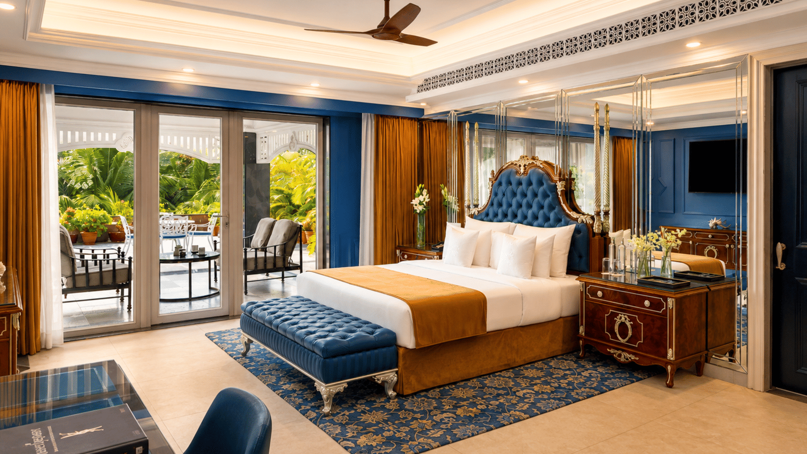 Presidential villa bedroom with a king bed, a tufted bench, a wardrobe and a terrace with outdoor seating at MAYFAIR Palm Beach Resort, Gopalpur-on-Sea.