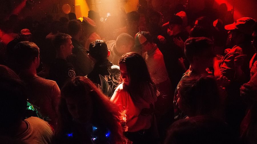 Plaza club bustling with people dancing and enjoying themselves under a vibrant dance floor.