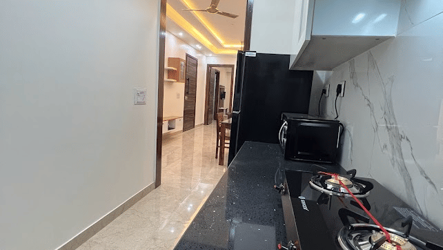 Corridor of Lime Tree Hotels & Service Apartment Private Limited featuring dark flooring and luggage placed along the hallway.