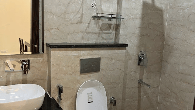 Bathroom of Lime Tree Hotels & Service Apartment Private Limited featuring a shower, a toilet, and a wash basin.