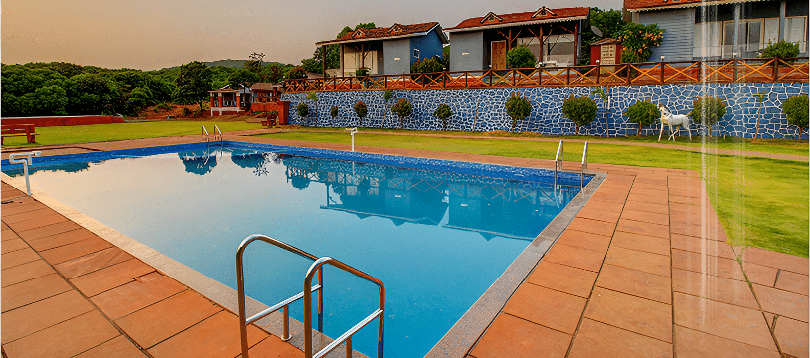 Sparkling pool beside a modern resort with terrace seating at De Soul Santé Hotels & Resorts.