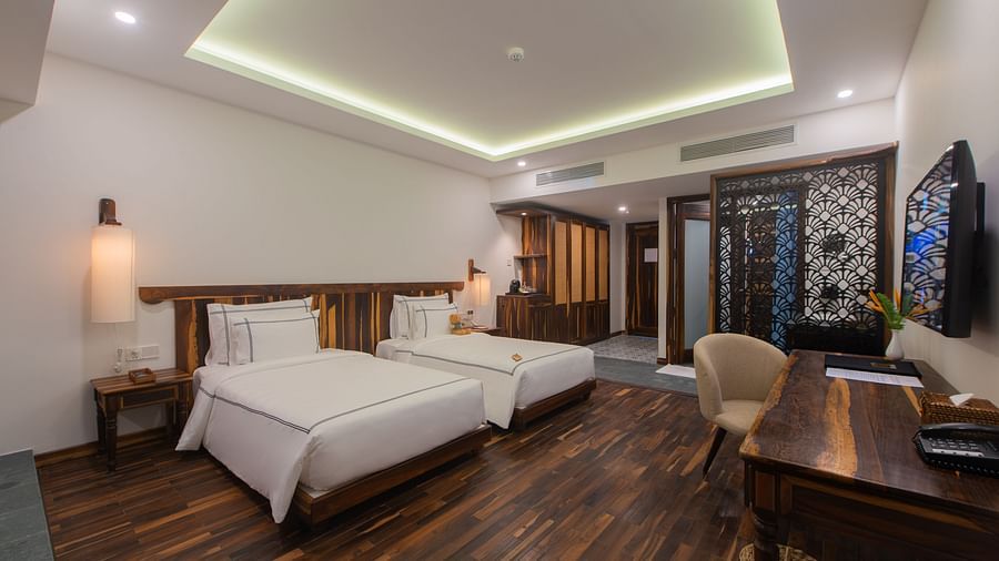 A rustic room with twin beds, ambient lighting and comfortable furniture - Alibu Resort Nha Trang
