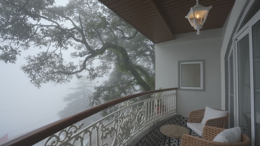 Balcony view overlooking misty trees with elegant outdoor seating - Mayfair Cafe & Suites, Dalhousie