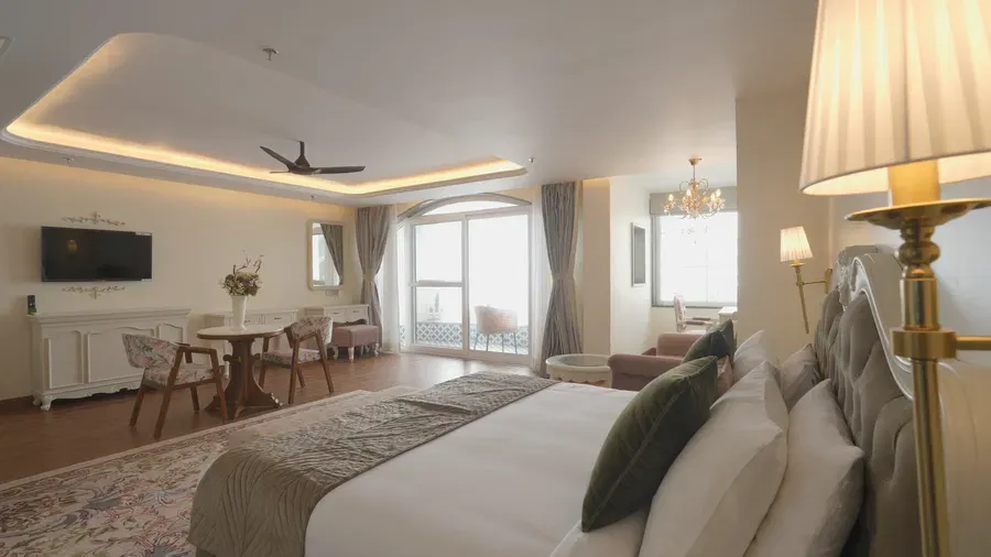 Luxury suite featuring a queen size bed, soft lighting, and refined decor - Mayfair Cafe & Suites, Dalhousie