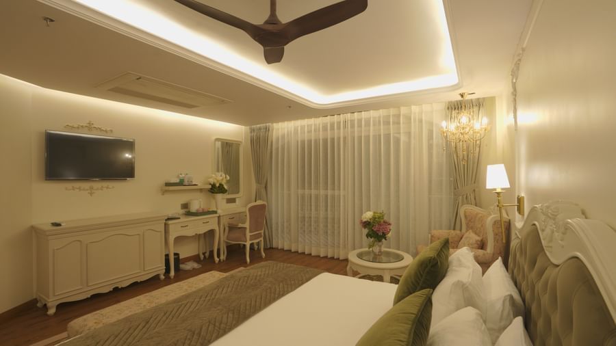 Elegant bedroom with a ceiling fan, muted lighting, and tasteful furnishings - Mayfair Cafe & Suites, Dalhousie
