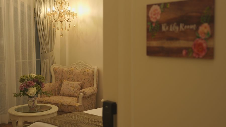 Cosy seating corner with armchairs, a round table, and floral decor - Mayfair Cafe & Suites, Dalhousie