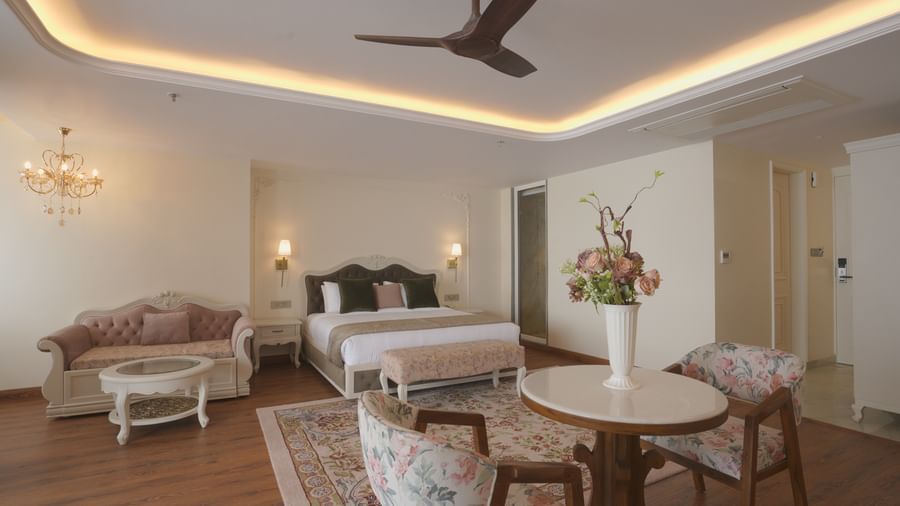 Lounge area with floral armchairs, a centre table, and warm recessed lighting - Mayfair Cafe & Suites, Dalhousie