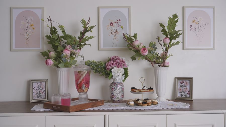 White sideboard decorated with vases of fresh flowers and framed artwork - Mayfair Cafe & Suites, Dalhousie