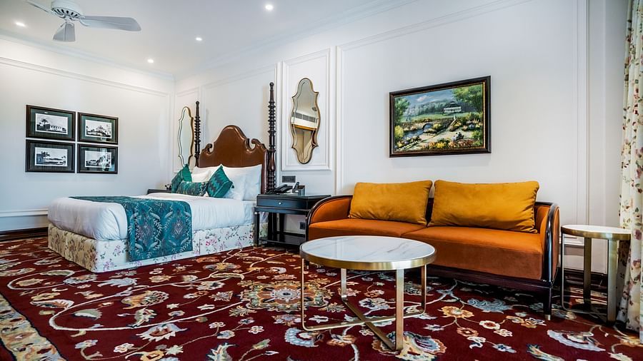 Contemporary room with twin beds, bright wall art, and cosy yellow couch