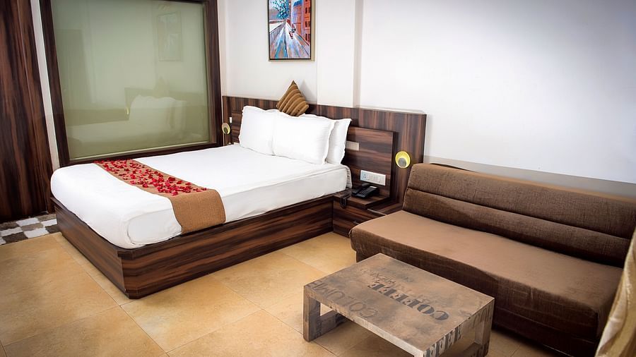 Adamo Resort Matheran - Regent Room with a sofa beside the bed