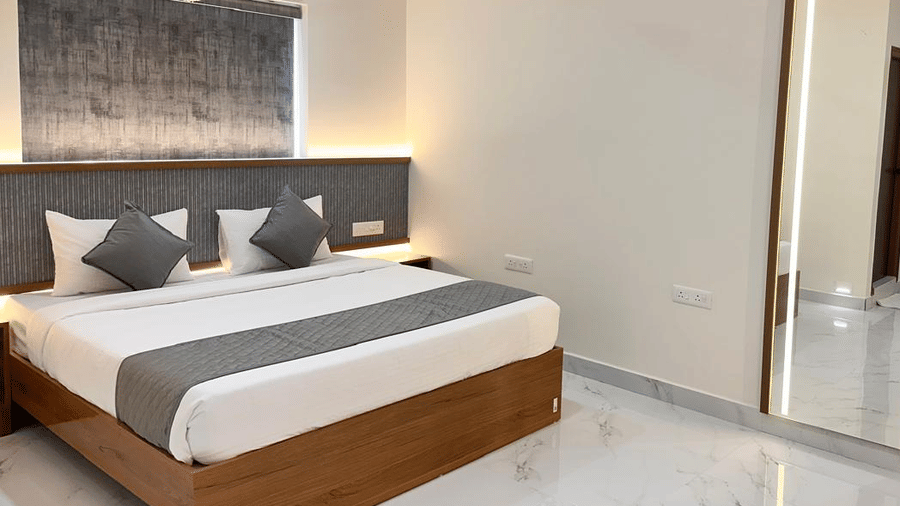 View of a bedroom featuring a double bed and a wall-mounted mirror | Hotel Aurora Bliss