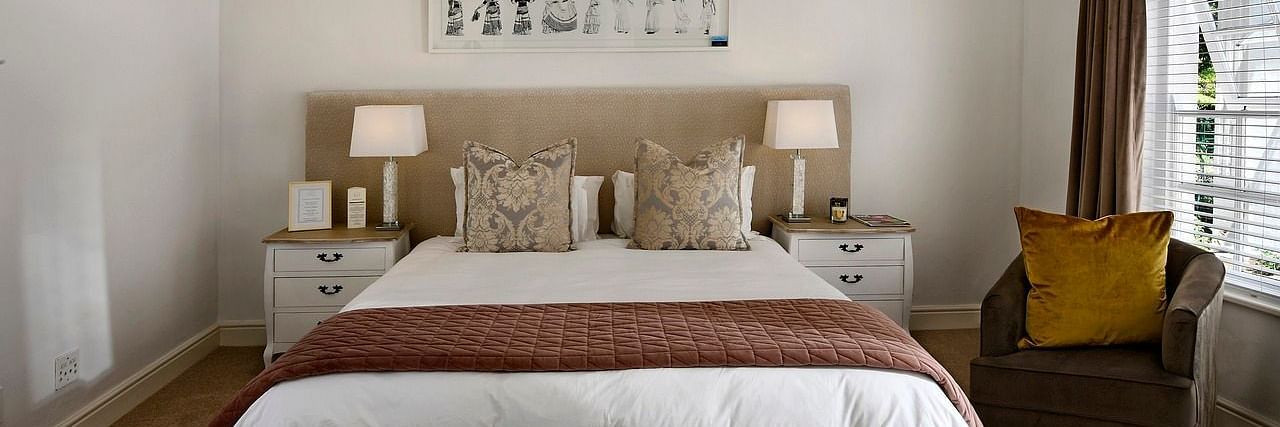 A double bed with a ceiling fan hanging over it in a bedroom.