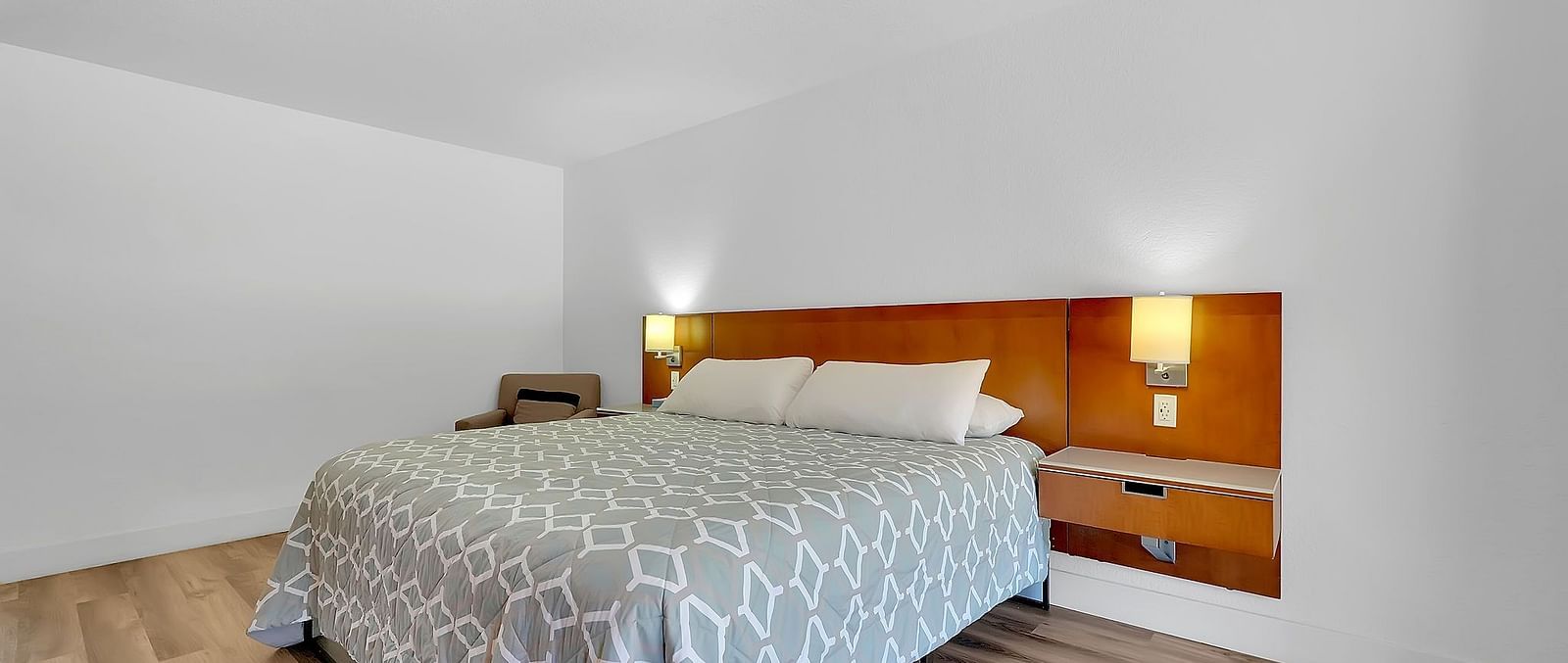 A view of a room at Amador Hotel with a double bed and side lamps.