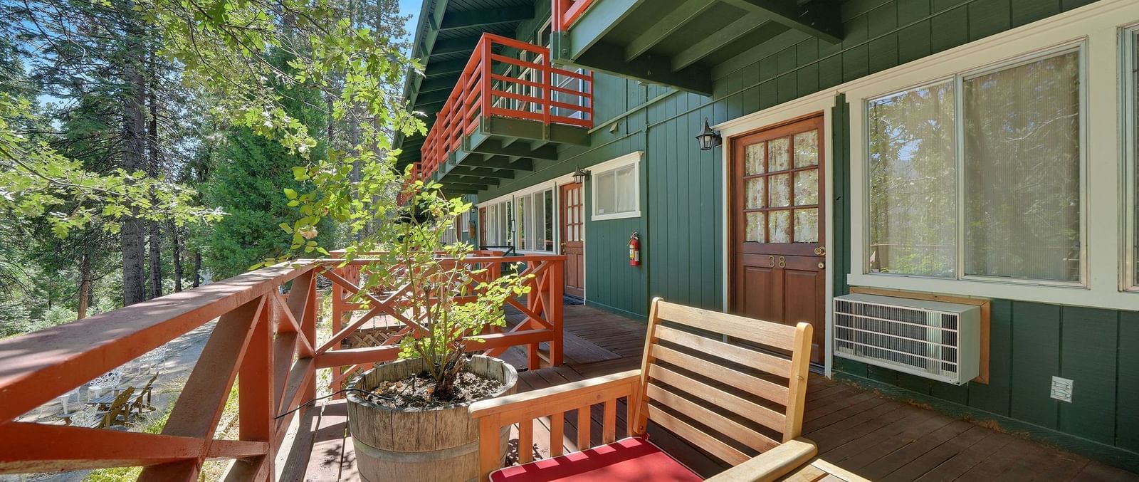 Outdoor patio area of a cabin with forest green exterior at Narrow Gauge Inn.