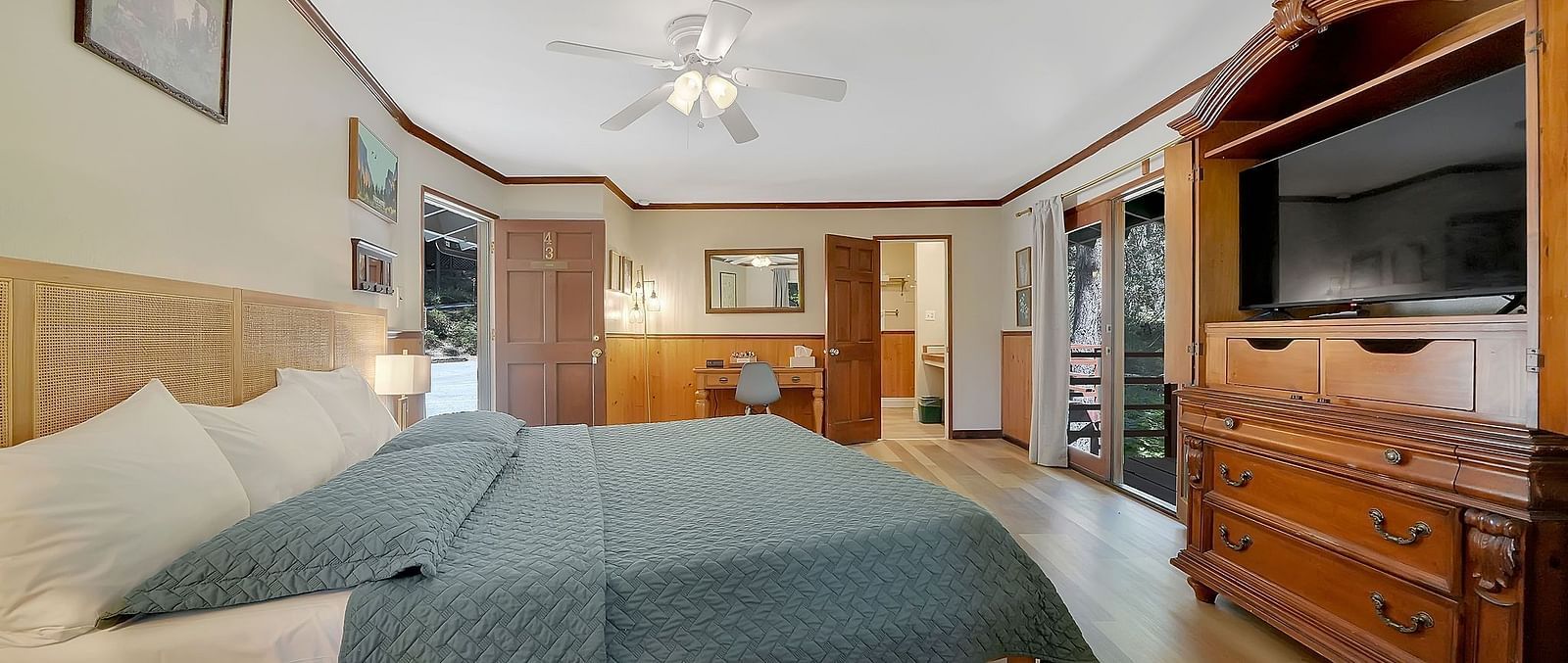 A view of a room at Narrow Gauge Inn with a double bed and a television.
