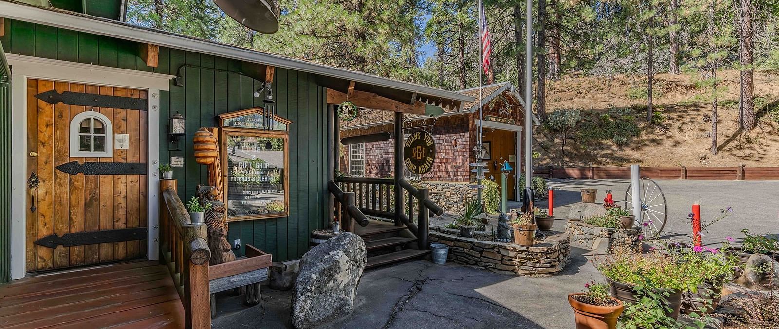 Exterior of a cabin with pastel green colour and potted plants placed outside.