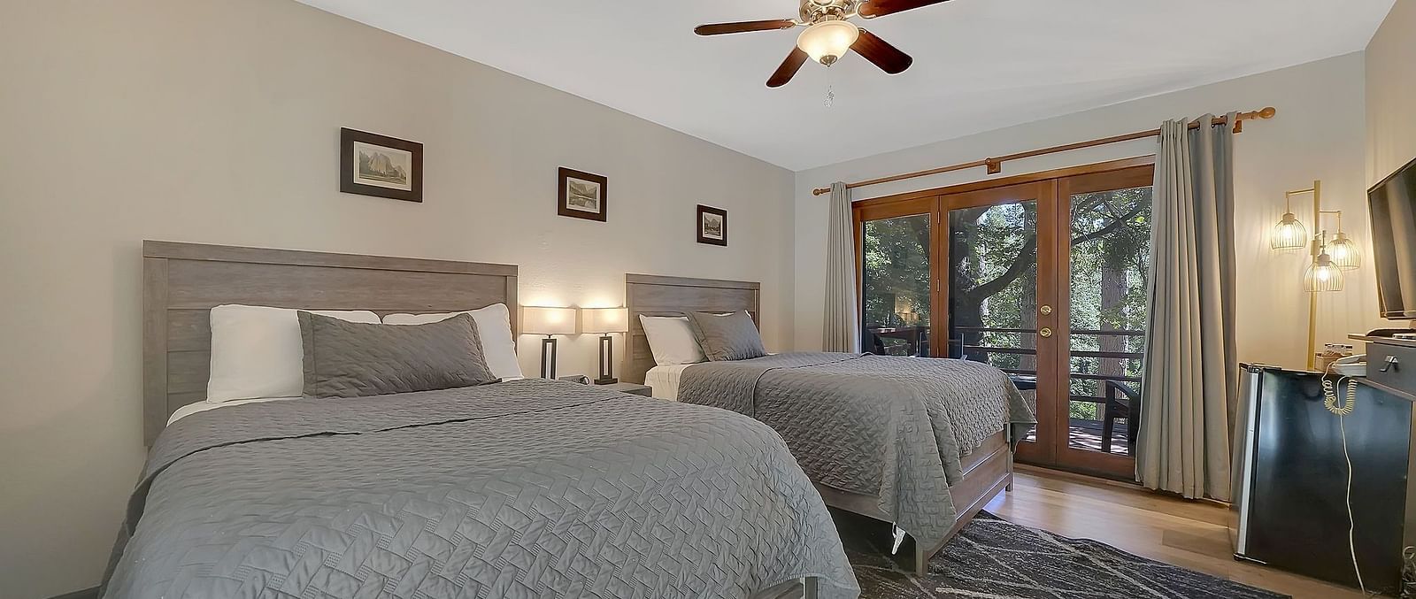 A view of a room at Narrow Gauge Inn with twin beds and sliding doors opening to a balcony.