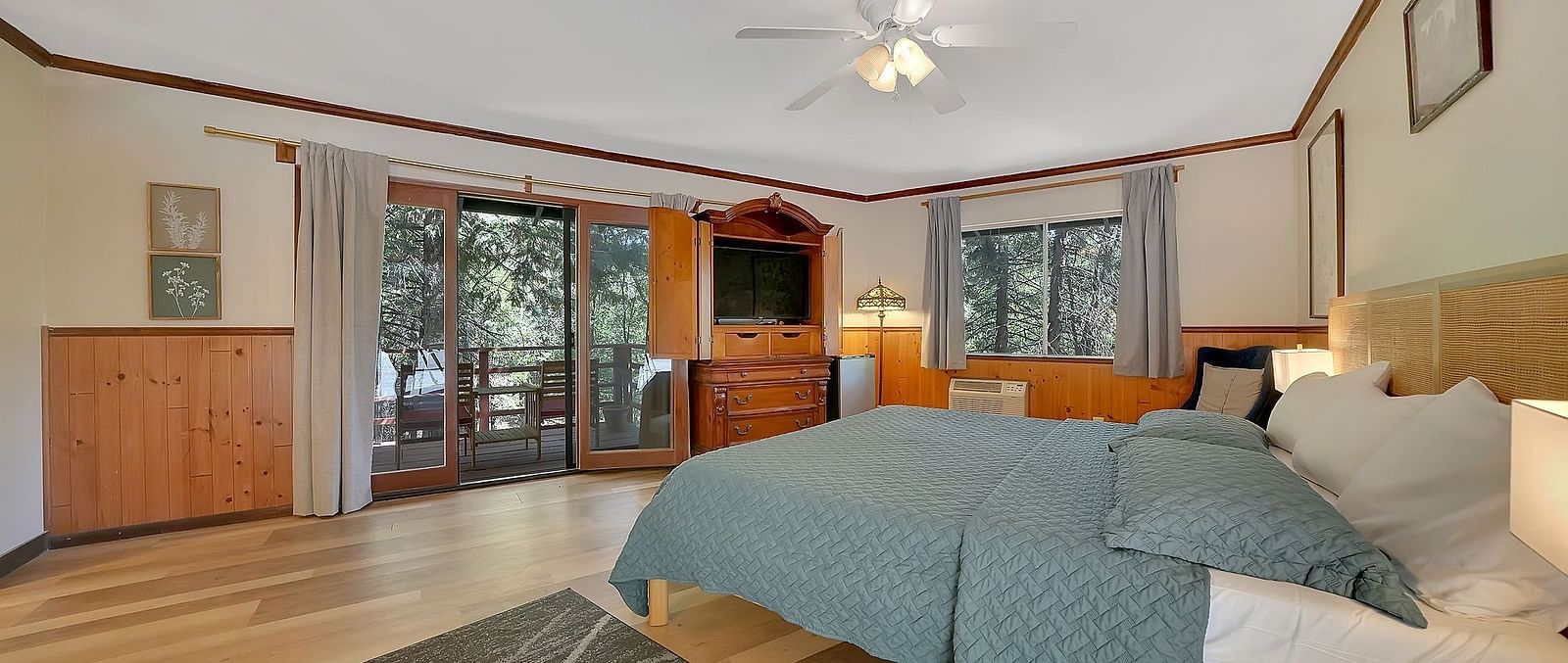 A room at Narrow Gauge Inn with a double bed and sliding doors opening up to a balcony with seating.