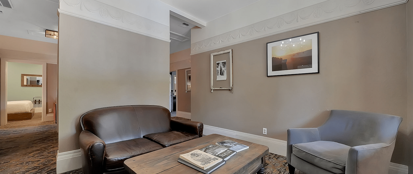 Living room area of a suite at The Groveland Hotel with sofa seating and a coffee table.
