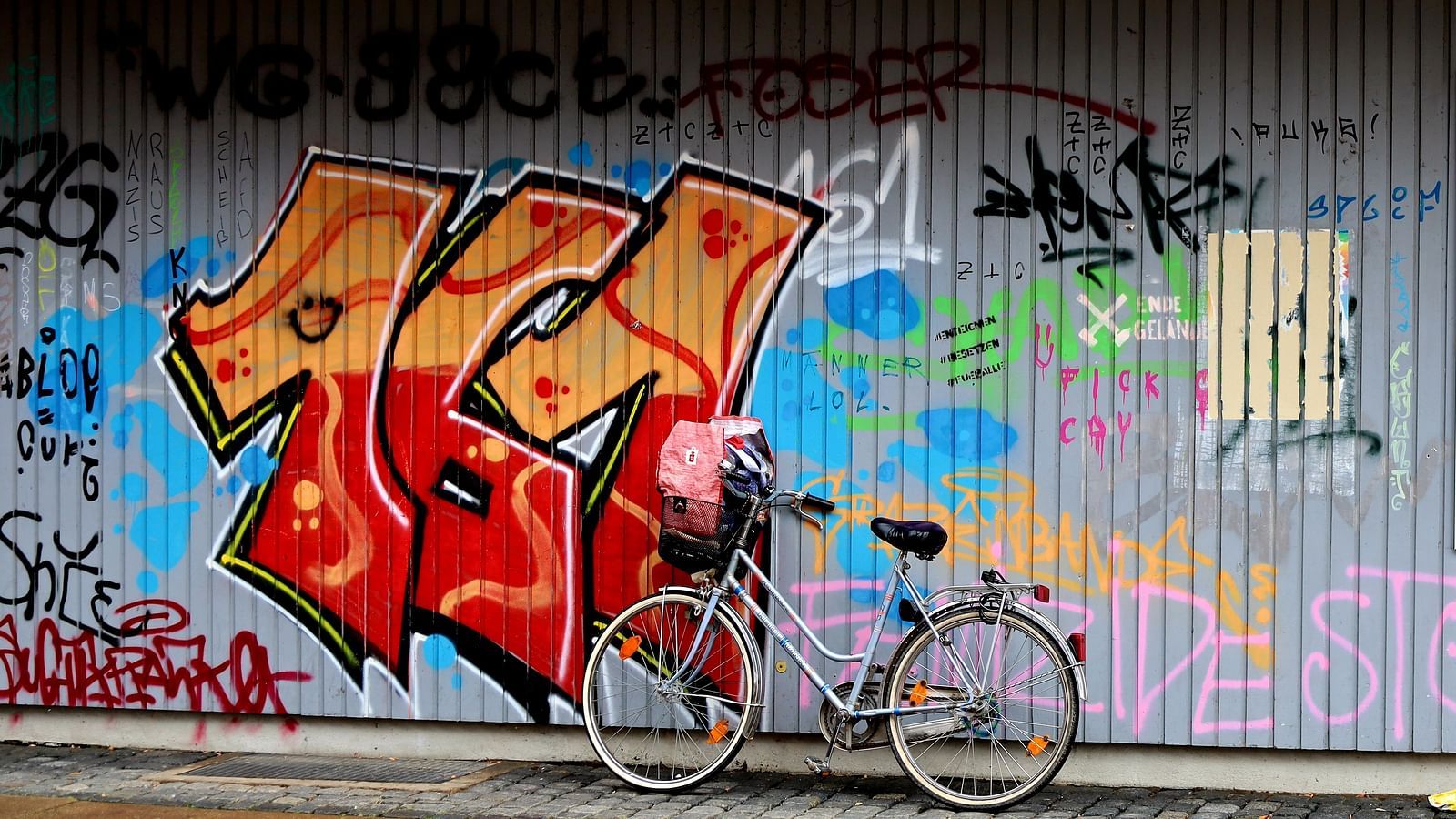 An overview of a street art on a wall with a bicycle parked on it.