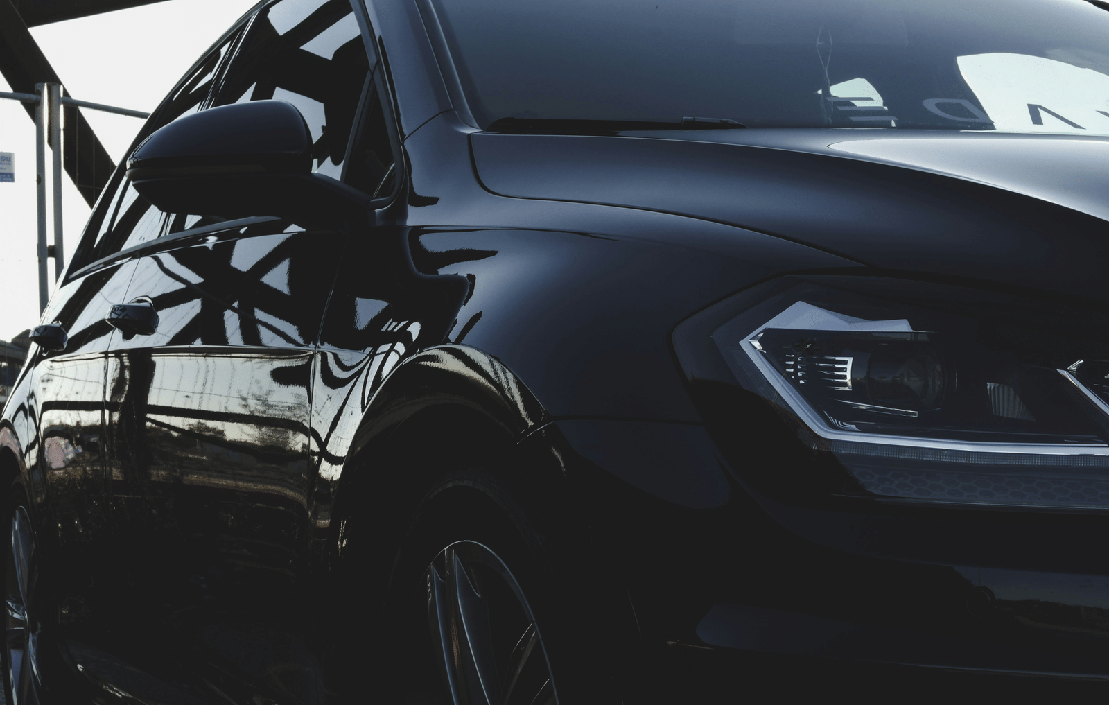 A low-angle close-up of a sleek black vehicle used for guest transport.