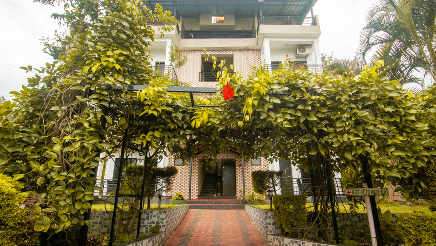 Facade of a with plants covering the archway in front at Coorg Jungle Camp Backwater Resort, Kushalnagar.
