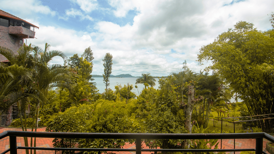 Image of a balcony with a view of the lush greenery and water body in front of it at Coorg Jungle Camp Backwater Resort, Kushalnagar.