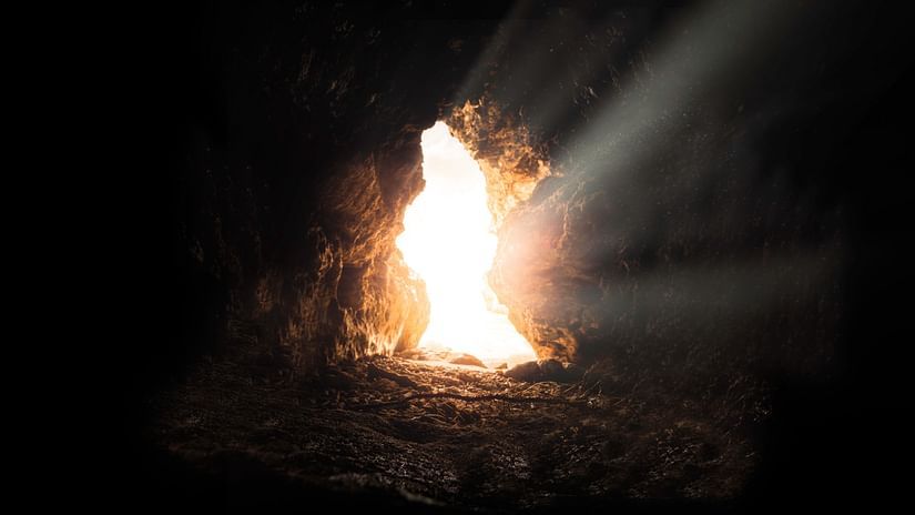inside view of a cave with sun rays coming in