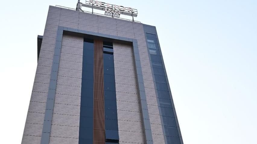 The tall building of Melior Inn is depicted against a clear sky.