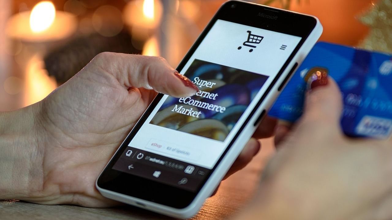Woman making an online purchase using a smartphone and credit card – Seamless East Africa 2025 e-commerce visual