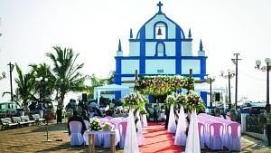 A church during the day adorned with a wedding setup featuring a red carpet and decorated chairs leading to the chapel entrance.