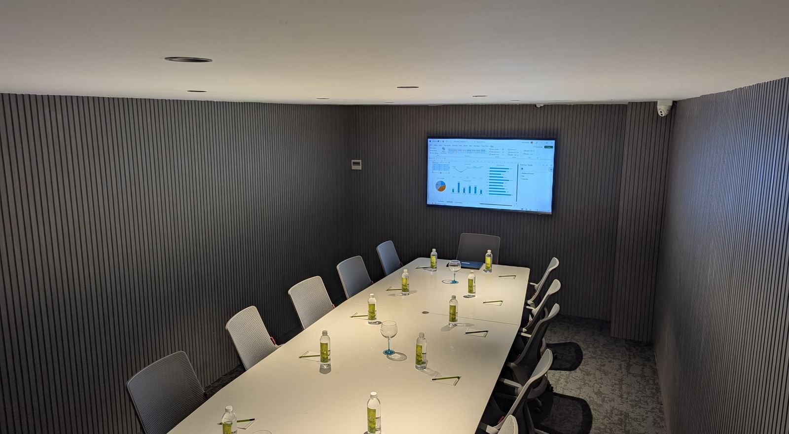 Conference table and presentation screen with grey walls at Fressotel, Kanakapura Road, Bangalore.