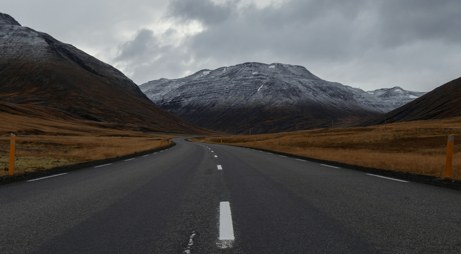An overview of a highway with single lanes on either side and a mountain in the background.