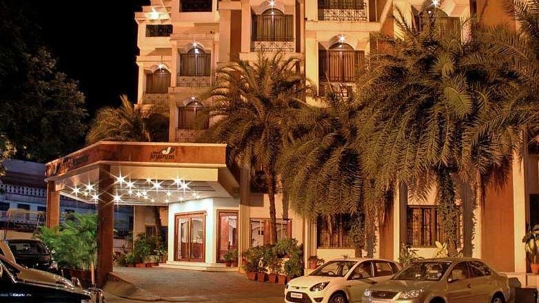 Image if exterior of the hotel with cards parked in front of it - Jayaram Hotel, Pondicherry