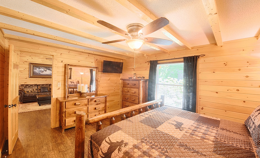 corner view image of a bedroom with a double bed with ample natural light coming from the window beside it - Historic Tapoco Lodge